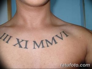 Фото тату на груди мужчины: черные римские цифры, выстроенные в ряд. Минималистичный стиль, четкие линии, простая композиция.