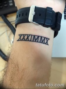 Фото тату с римскими цифрами XXXIMMMX на запястье. Черный рисунок татуировки, простой стиль, памятная дата.