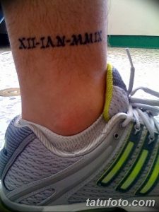 Фото тату на лодыжке: горизонтальная линия римских цифр, выполненная черными чернилами в минималистичном стиле.