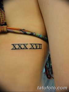 Фото тату с изображением римских цифр XXX XVII, выполненного в простом и лаконичном стиле на руке. Эскиз татуировки символизирует важную дату.