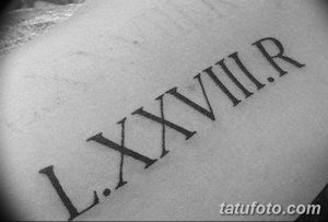 Фото тату: небольшая татуировка римскими цифрами 'LXXVIII.R' на запястье. Черный цвет, тонкие линии, минималистичный стиль.