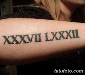 Фото тату: татуировка с римскими цифрами 'XXXVII LXXXII' на предплечье. Черный цвет, четкие линии, классический стиль.