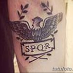 Фото тату на руке с изображением римского орла и надписью SPQR, выполненное в черно-серых тонах. Эскиз татуировки символизирует гордость и силу.