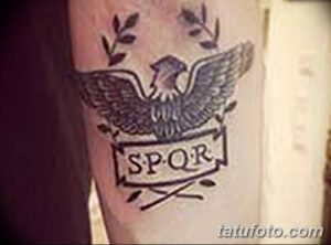 Фото тату на руке с изображением римского орла и надписью SPQR, выполненное в черно-серых тонах. Эскиз татуировки символизирует гордость и силу.