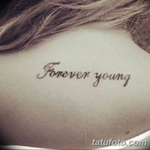Фото тату с надписью 'Forever Young' выполненной каллиграфическим шрифтом на шее. Татуировка выполнена в черных тонах.