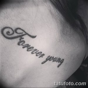 Фотография татуировки с надписью 'Forever Young', выполненной каллиграфическим шрифтом на шее. Нежный и элегантный рисунок татуировки.