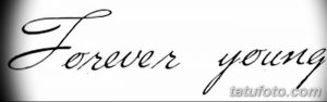 Фото тату надписи 'Forever Young' выполненной каллиграфическим шрифтом. Минималистичная и стильная татуировка.