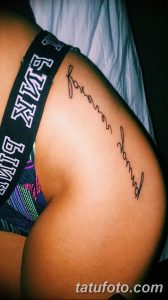 Фото тату с надписью 'Forever Young' на боку, выполненной тонкой линией. Минималистичный рисунок татуировки для девушек, подчеркивающий изящество.