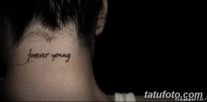 Фото тату на затылке: надпись 'forever young' выполненная тонким черным шрифтом.