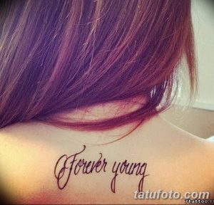 Фото тату на задней части шеи: изящная надпись 'Forever Young' выполненная тонким черным контуром.