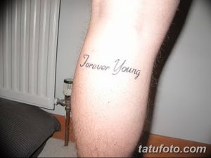 Фото тату на ноге: простая надпись 'forever young', выполненная черным шрифтом, с акцентом на элегантность и минимализм.