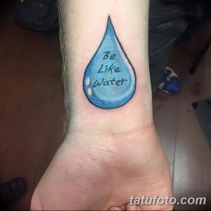 Фото тату капли воды на запястье с надписью "Be Like Water". Минималистичный рисунок татуировки в голубых тонах.