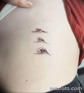 Фото тату с изображением трех волн на боку, выполненное в минималистичном стиле. Рисунок выглядит стильно и лаконично.