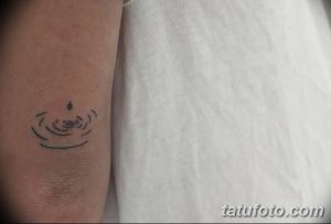 Фото тату: маленькая черно-белая татуировка капли воды на руке, выполненная в минималистичном стиле. Тонкие линии и лаконичный дизайн.