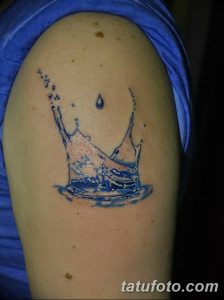 Фото тату капли воды на плече. Простой и элегантный рисунок татуировки в стиле минимализм, выполненный в синих тонах.