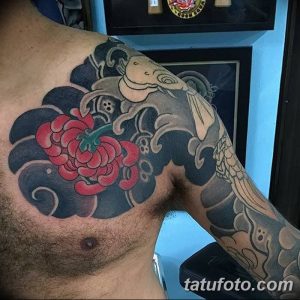 Фото тату: На плече и груди изображена большая японская татуировка с карпом кои, волнами и цветком пиона, выполненная в традиционном стиле.