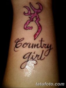 Фото тату с изображением рогов оленя и надписи "Country Girl" на запястье. Милый и женственный рисунок татуировки в розовых тонах.