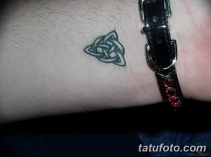 Фото небольшой татуировки кельтского узла на запястье. Простой, но элегантный рисунок в серо-зеленых тонах, идеально подходящий для первого тату.