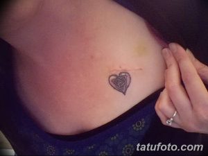 Фото тату кельтского узла в форме сердца, выполненного в черных тонах на ключице. Изображение символизирует любовь, верность и защиту.