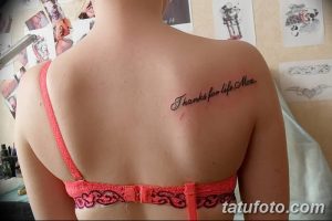 Фото тату надписи "Thanks for life, Mom" на спине девушки. Простая и трогательная татуировка, выражающая любовь и благодарность.