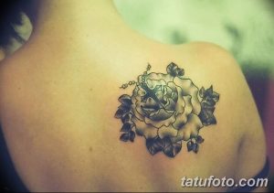 Фото тату розы с крестом на лопатке. Черно-белый рисунок, сочетающий символы любви, веры и надежды.