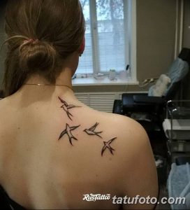 Фото тату маленьких птиц на спине. Простые и изящные рисунки птиц в полете, выполненные в минималистичном стиле.