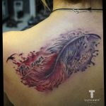 Фото тату пера с надписями "Per amor" и "Ad astra" на лопатке. Цветной рисунок с использованием розовых, фиолетовых и черных оттенков. Идеально для романтичных натур.