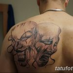 Фото тату на спине: изображение двух театральных масок – трагедии и комедии, выполненное в черно-серых тонах с выразительной мимикой.