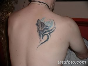 Фото тату: Татуировка волка, воющего на луну, в стиле трайбл на спине мужчины. Оригинальный рисунок татуировки.