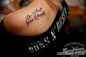 Фото тату с черной надписью "Do What You Should" на плече девушки. Простой и лаконичный рисунок татуировки.