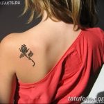 Фото тату на лопатке: маленькая черная роза с детально прорисованными лепестками и стеблем. Идеально для любителей классических мотивов.