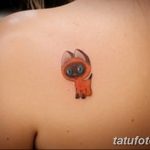 Фото милой татуировки котенка на плече. Небольшой рисунок котенка с большими глазами, выполненный в ярких и красочных тонах.