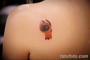 Фото милой татуировки котенка на плече. Небольшой рисунок котенка с большими глазами, выполненный в ярких и красочных тонах.