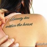 Фото татуировки с надписью "Beauty lies within the heart" на плече. Красивый шрифт и аккуратное исполнение.