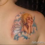 Фото тату ангела на плече, выполненное в акварельном стиле с использованием пастельных тонов. Изображен ангел с распущенными волосами и нежным выражением лица.