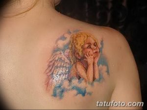 Фото тату ангела на плече, выполненное в акварельном стиле с использованием пастельных тонов. Изображен ангел с распущенными волосами и нежным выражением лица.