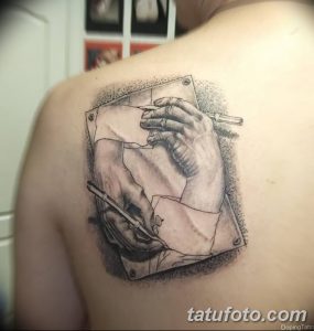 Фото тату: невероятно реалистичная татуировка руки, держащей карандаш и рисующей на листе бумаги, выполнена в черно-серых тонах.