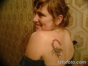 Фото тату скорпиона на лопатке женщины. Реалистичный рисунок с детальной проработкой панциря и жала. Черно-серые тона.
