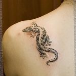 Фото тату: реалистичная ящерица, ползущая по плечу. Детализированная проработка чешуи и яркие цвета.