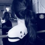 Фото тату звезд и птиц на шее девушки. Минималистичный стиль, контурный рисунок, черно-белая гамма.