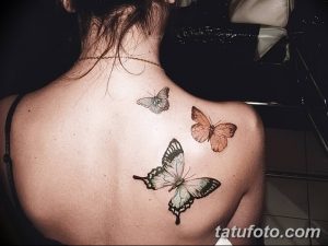 Фото тату трех бабочек на спине девушки. Разные размеры и оттенки, реалистичный рисунок.