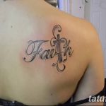 Фото татуировки надписи 'Faith' (Вера) с изображением креста на плече. Черно-серая татуировка с каллиграфическим шрифтом.