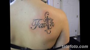 Фото татуировки надписи 'Faith' (Вера) с изображением креста на плече. Черно-серая татуировка с каллиграфическим шрифтом.