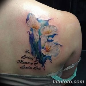 Фото татуировки с изображением букета ирисов и надписью "In Loving Memory of Linda Lou". Татуировка выполнена в акварельном стиле.