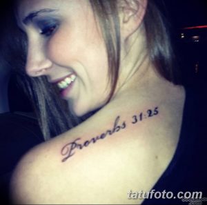 Фото тату надписи "Proverbs 31:25" на ключице. Элегантный шрифт, религиозный смысл. Подходит для верующих людей.
