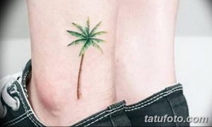 Фото тату: небольшая, реалистичная татуировка пальмы на лодыжке. Черно-белый рисунок татуировки, выполненный в минималистичном стиле.