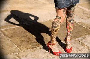 Фото тату на ноге: японский дракон, обвитый цветами и ветвями сакуры. Красочный и детализированный рисунок татуировки.