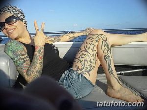 Фото тату: впечатляющий тату-рукав на ноге, выполненный в стиле трайбл с использованием черных узоров и орнаментов.