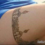 Фото тату: красивый рисунок в стиле мехенди на женском бедре, выполненный в коричневых тонах с использованием сложных узоров и орнаментов.