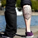 Фотография татуировки на голени, изображающей компас с якорем внутри, выполненной в черно-белых тонах, символизирующей путешествия и надежду.